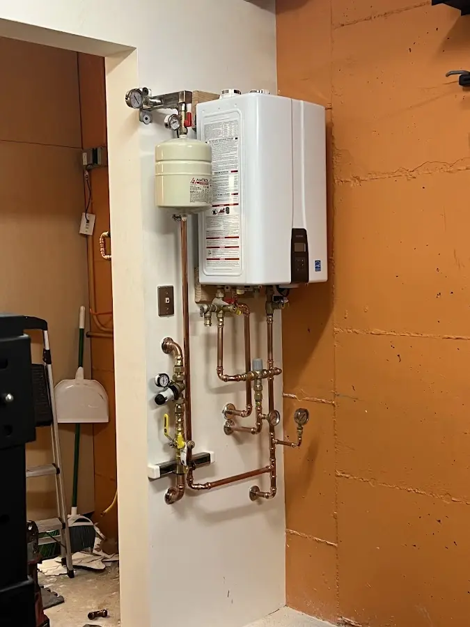 Plumbing technician inspecting water heater connections in Mount Penn